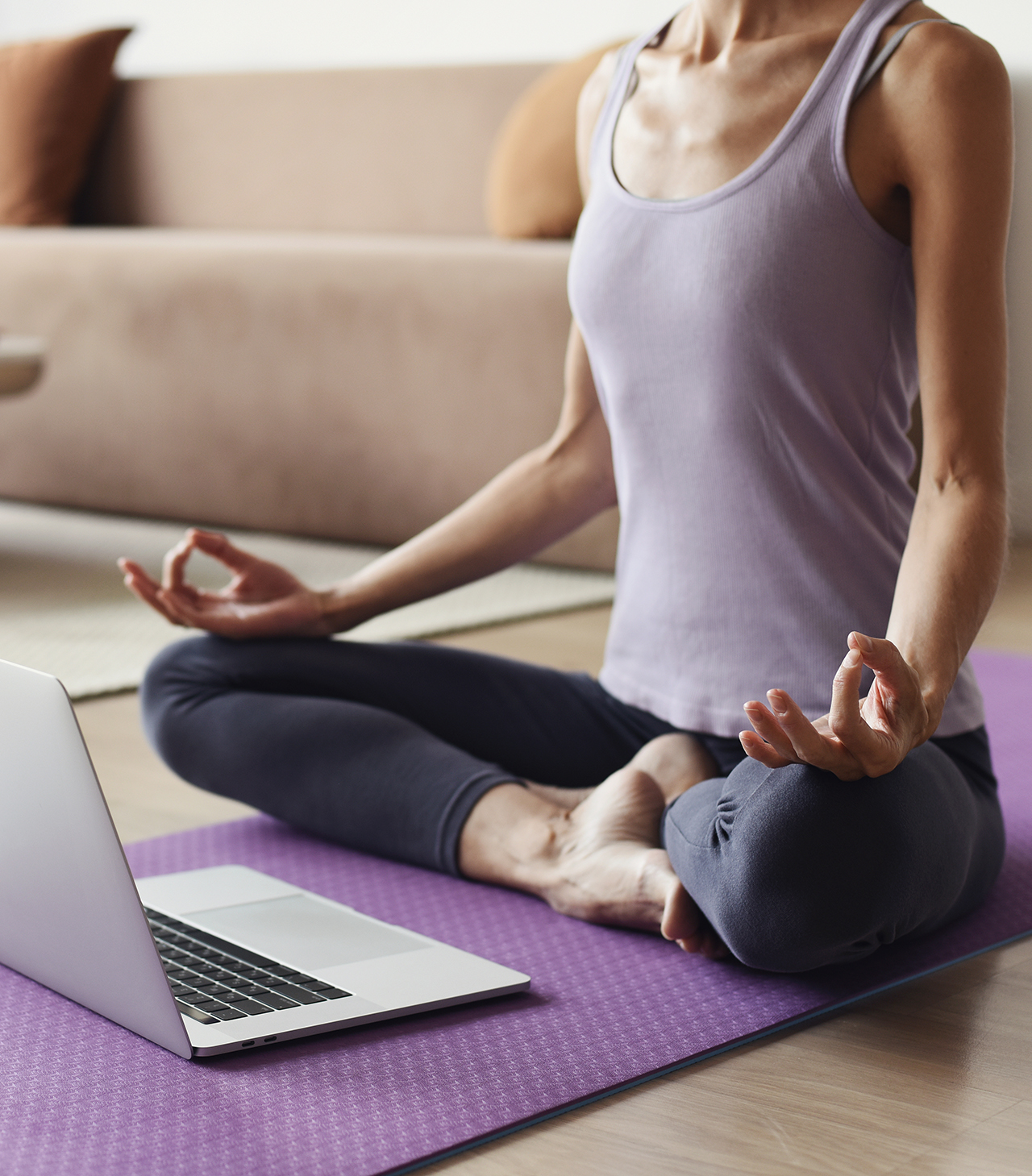 Frau in Yogaposition vor laptop